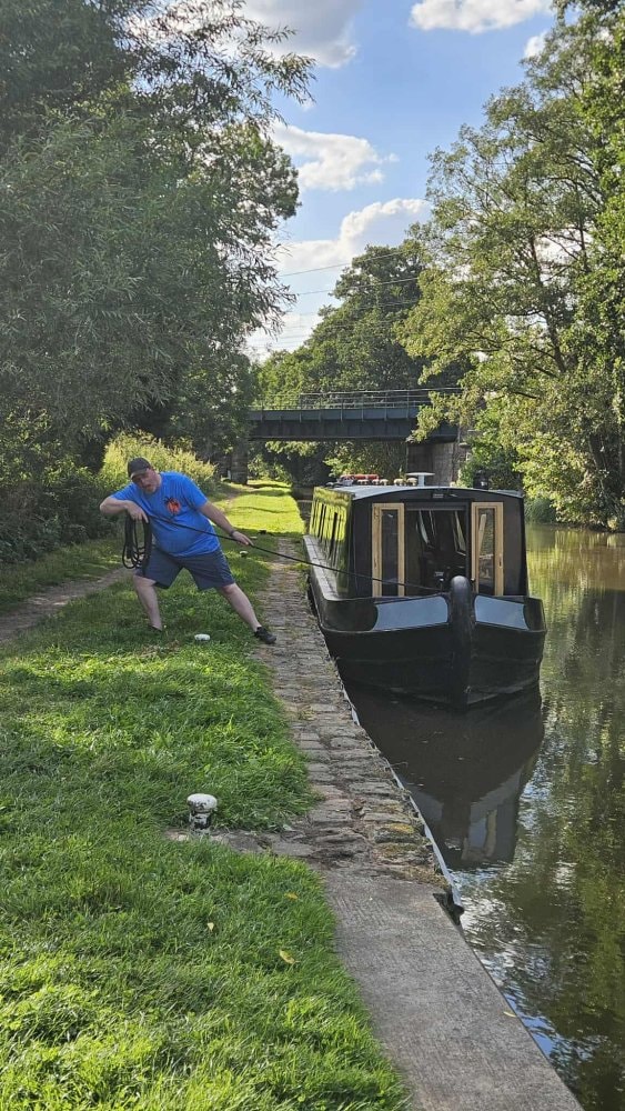 Pulling a narrowboat to the bank with a mooring rope on the towpath