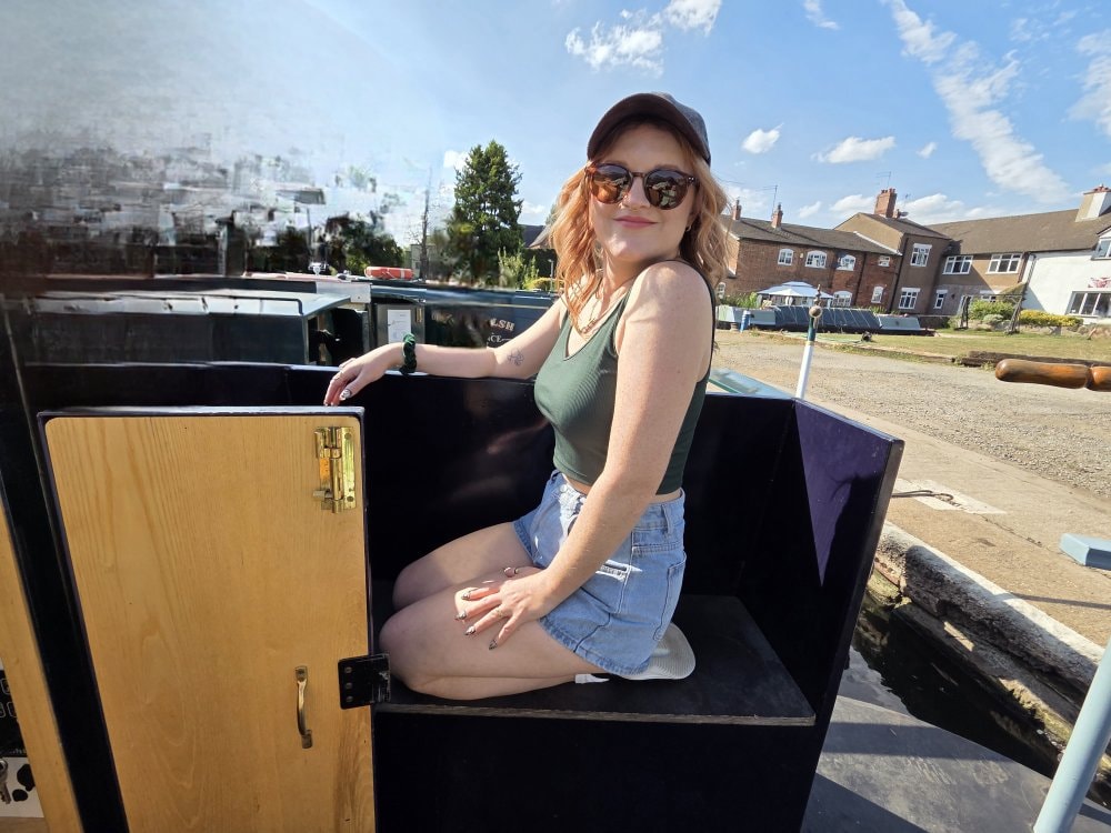 Standing at the stern of a narrowboat on a sunny day on the canal